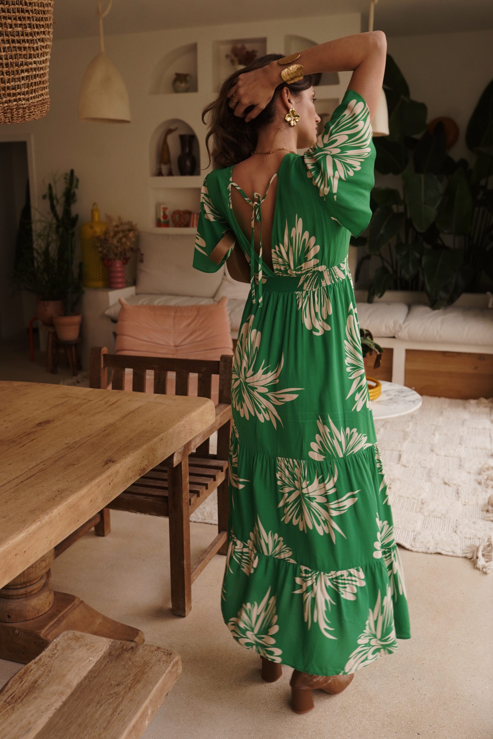 Robe longue en viscose verte à motifs floraux écrus, col V et manches papillon. Une pièce bohème chic, fluide et élégante pour toutes vos occasions estivales.