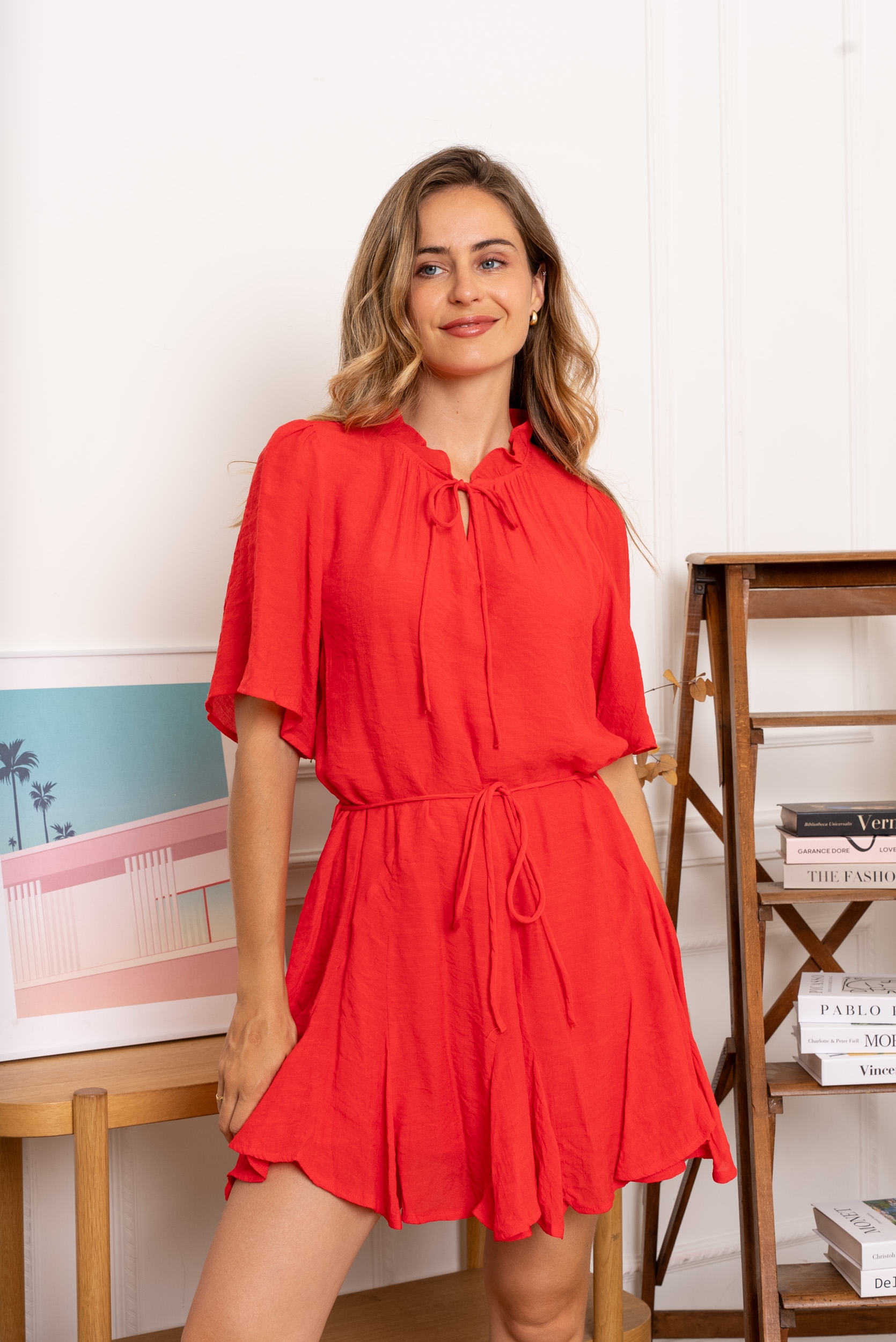 Coupe fluide très féminine. Coloris corail éclatant, parfait pour la belle saison. Encolure ronde avec lien à nouer. Manches papillon légères et élégantes.