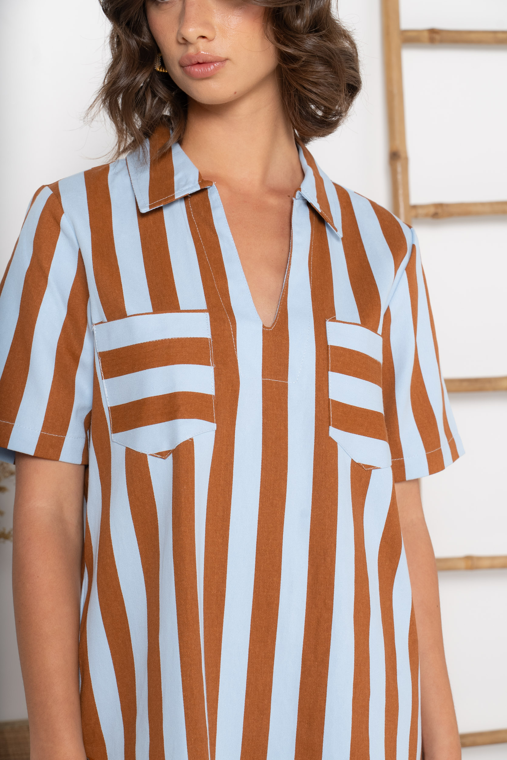 Coupe droite confortable qui convient à toutes les morphologies. Rayures verticales ciel et chocolat qui élancent la silhouette. Col chemise avec ouverture en V très féminin.