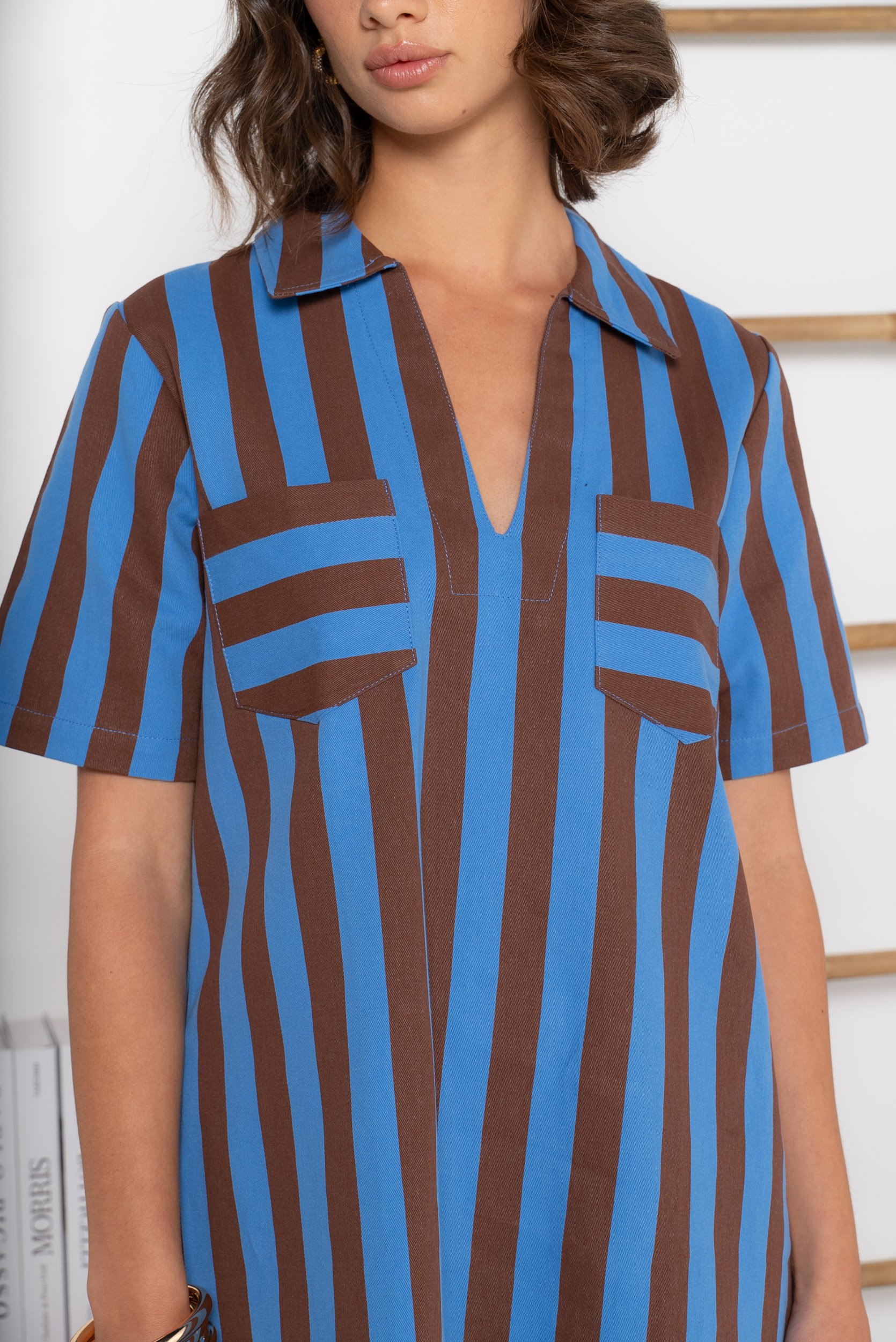 Coupe droite confortable et flatteuse. Rayures verticales chocolat et bleu roi qui élancent la silhouette. Col chemise avec ouverture en V.